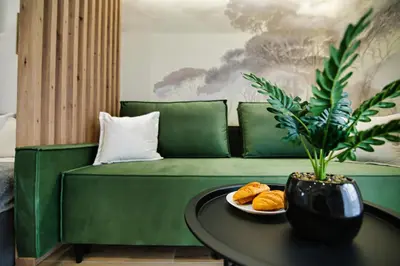 a green couch with a plate of food on a table at Good rest in 52 in Zator