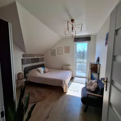 a small bedroom with a bed and a window at Apartament Pastelowy in Kraków