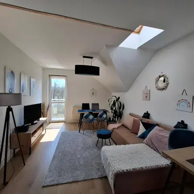a living room with a couch and a table at Apartament Pastelowy in Kraków