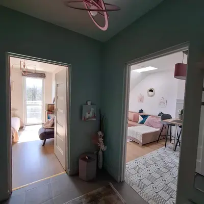 a living room with green walls and a bedroom at Apartament Pastelowy in Kraków
