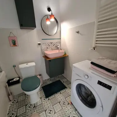 a bathroom with a washing machine and a sink at Apartament Pastelowy in Kraków