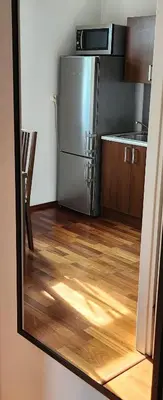 a kitchen with a refrigerator and a wooden floor at Nature in Kraków
