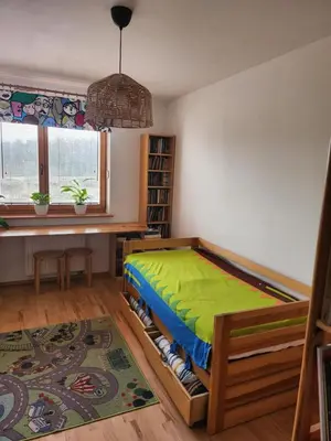 a bedroom with a bed with a green blanket at Nature in Kraków