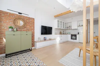 a kitchen and living room with a brick wall at Unique Air-conditioned Apartment Dietla Cracow by Noclegi Renters in Kraków