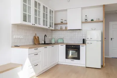 a white kitchen with white cabinets and a refrigerator at Unique Air-conditioned Apartment Dietla Cracow by Noclegi Renters in Kraków