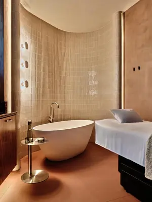 a bathroom with a tub next to a bed at Zinar Castle in Kraków