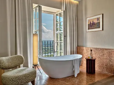 a bathroom with a tub and a chair and a window at Zinar Castle in Kraków