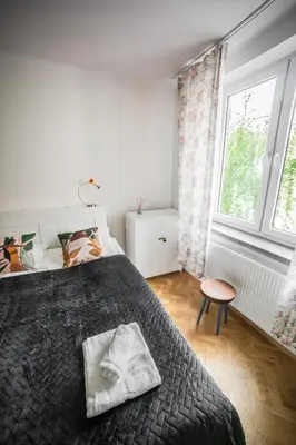 a bedroom with a large bed and a window at Vistula River Modern Apartment by BookingHost in Kraków