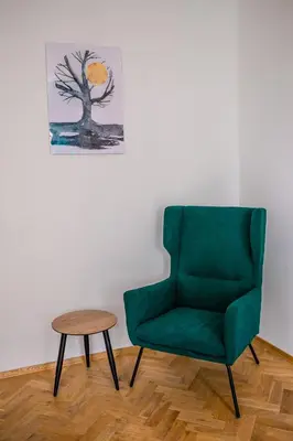 a green chair and a table in a room at Vistula River Modern Apartment by BookingHost in Kraków