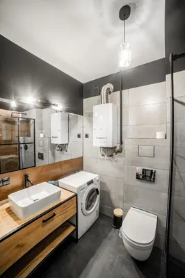 a bathroom with a washing machine and a sink at Vistula River Modern Apartment by BookingHost in Kraków