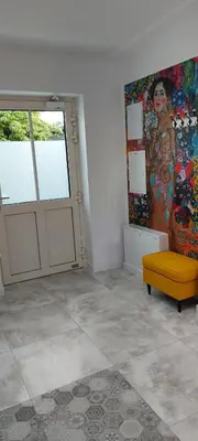 a room with a painting on the wall and a yellow bench at Juwel Apartments Kraków z widokiem na Wawel 44 in Kraków