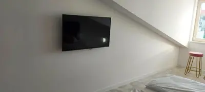 a flat screen tv hanging on a white wall at Juwel Apartments Kraków z widokiem na Wawel 44 in Kraków