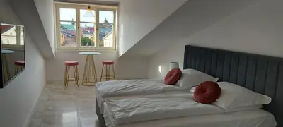 a bedroom with a bed with red pillows on it at Juwel Apartments Kraków z widokiem na Wawel 44 in Kraków