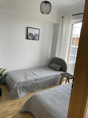 a bedroom with a bed and a chair next to a window at APARTAMENT AMZOHA in Zator