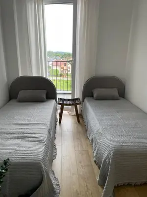 two beds sitting in a room with a window at APARTAMENT AMZOHA in Zator