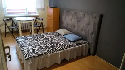 a bedroom with a bed and a table and a door at FEIDUM quarters rooms in Trzebinia