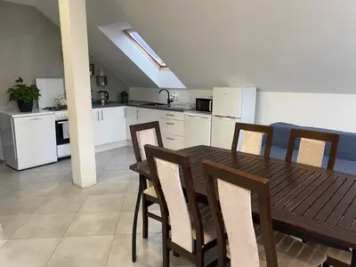 a kitchen with a wooden dining table and chairs at Noclegi Grojec in Grojec