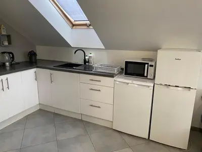 a white kitchen with a sink and a microwave at Noclegi Grojec in Grojec