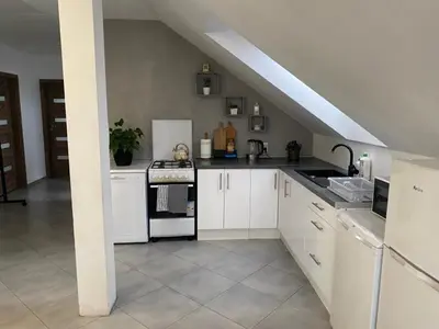 a kitchen with white cabinets and a white stove top oven at Noclegi Grojec in Grojec