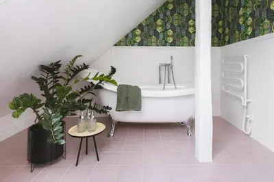a bathroom with a white tub and a potted plant at Chata Patykowo in Myślenice
