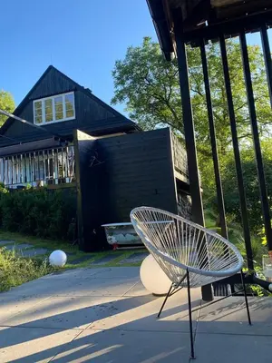a white chair sitting in front of a house at Chata Patykowo in Myślenice