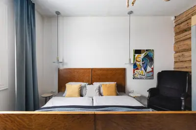 a bedroom with a bed and a black chair at Chata Patykowo in Myślenice