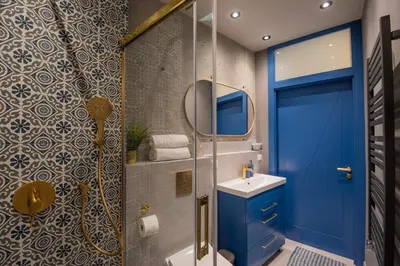 a bathroom with a blue door and a sink at City Lights Mostowa 6 in Kraków