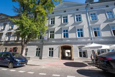 a large building with cars parked in front of it at City Lights Mostowa 6 in Kraków