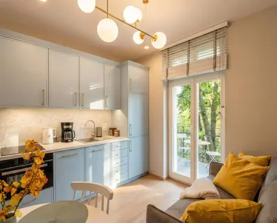 a kitchen and living room with a couch and a table at City Lights Mostowa 6 in Kraków