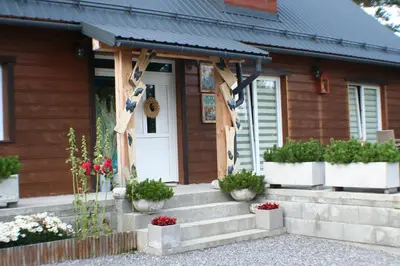 a house with potted plants on the front porch at Apartamenty Siedlisko pod Aniołem in Zubrzyca Górna