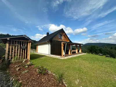 a small house on a field with a grass yard at Rajskie wzgórze słoikowo in Szczawa