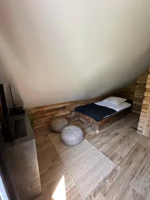 a bedroom with a bed and a wooden floor at Rajskie wzgórze słoikowo in Szczawa