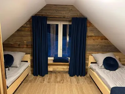 a bedroom with two beds and a window at Rajskie wzgórze słoikowo in Szczawa