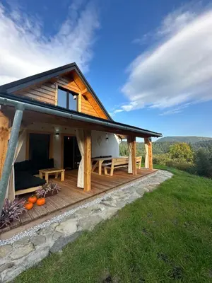 a log cabin with a deck with a view at Rajskie wzgórze słoikowo in Szczawa