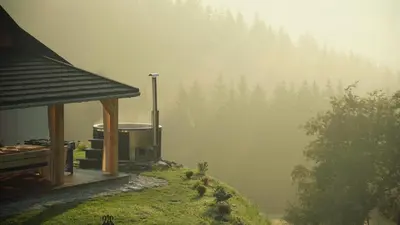 a misty view of a cabin on a hill with trees at Rajskie wzgórze słoikowo in Szczawa