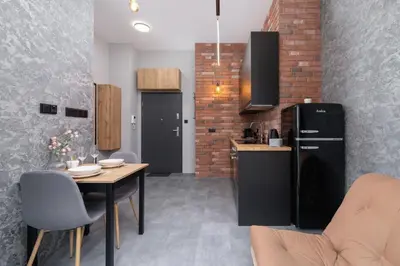 a kitchen with a table and a black refrigerator at Salsa Residence Pet-friendly by Noclegi Renters in Kraków