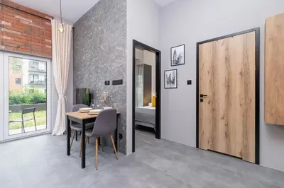 a dining room with a table and a wooden door at Salsa Residence Pet-friendly by Noclegi Renters in Kraków