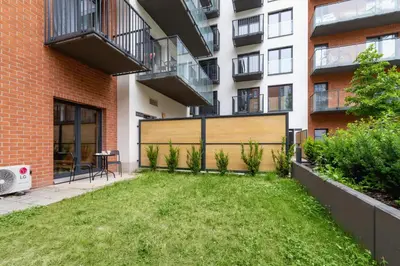 a backyard with a lawn in front of a building at Salsa Residence Pet-friendly by Noclegi Renters in Kraków