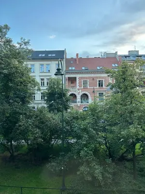 a street light in front of trees and buildings at Retoryka in Kraków