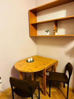 a wooden table and chairs in a room at Retoryka in Kraków