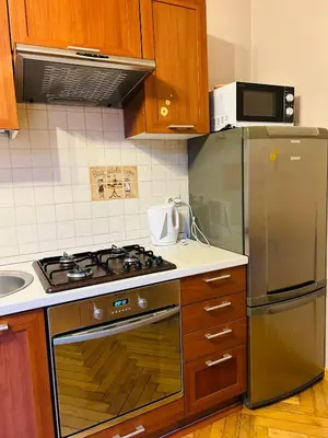 a kitchen with a stove and a stainless steel refrigerator at Retoryka in Kraków