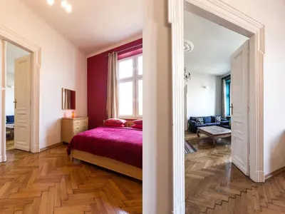 a bedroom with a bed and a large window at Stanislas Apartment in Kraków