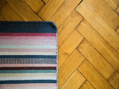 a rug sitting on a wooden floor next to a rugrats at Stanislas Apartment in Kraków