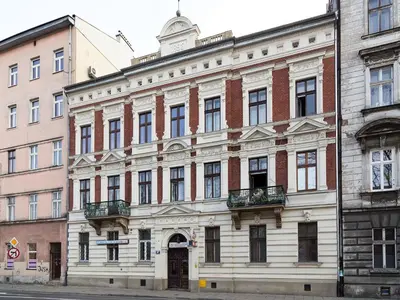 a large white building on a city street at Stanislas Apartment in Kraków