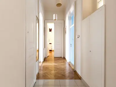 a hallway with white walls and wooden floors at Stanislas Apartment in Kraków