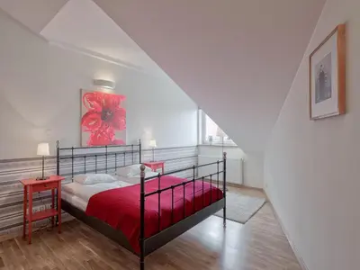 a bedroom with a red bed with a red blanket at Beauty of Krakow Apartment in Kraków