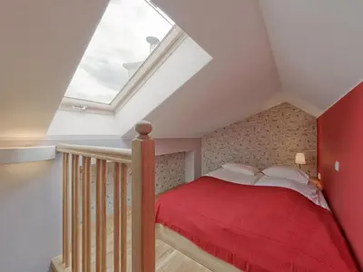 a attic bedroom with a bed with a red blanket at Beauty of Krakow Apartment in Kraków