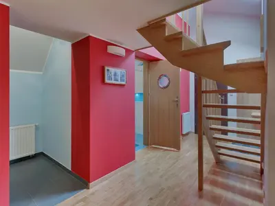 a staircase in a room with a red wall at Beauty of Krakow Apartment in Kraków