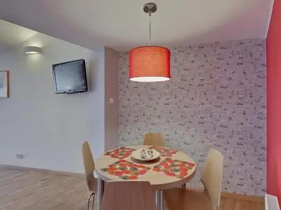a dining room with a table and chairs and a tv at Beauty of Krakow Apartment in Kraków