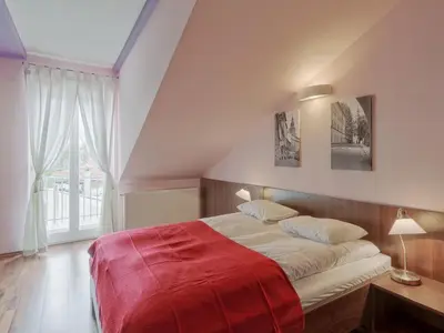 a bedroom with a large bed with a red blanket at Beauty of Krakow Studio in Kraków